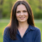 woman with long brown hair in dark blue shirt